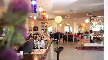 A bar area with a counter, stools, and a piano in the background.