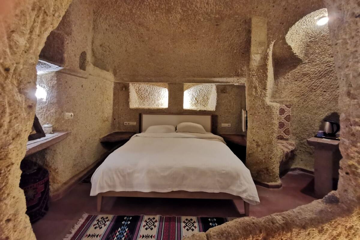 A room with a bed, a small table, and a window.