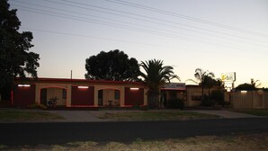 A motel with a red facade, multiple doors, and a signboard. - Nhill Oasis Motel (Nhill)