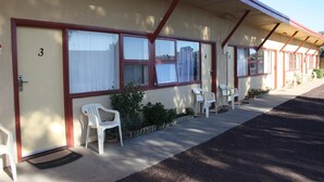 A motel with numbered rooms, outdoor seating, and a covered walkway. - Nhill Oasis Motel (Nhill)