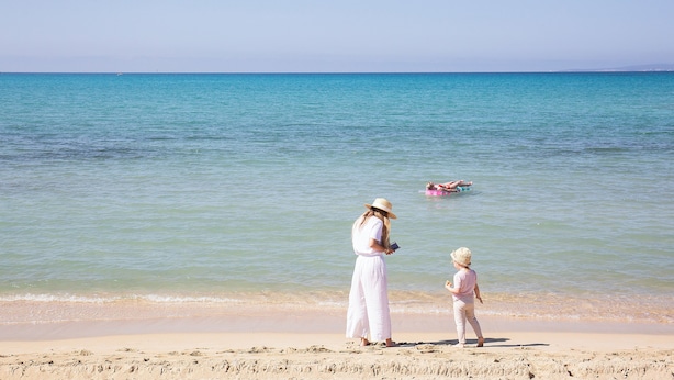 A beach scene with a woman and a child. - Hotel Playa Sol (Palma de Mallorca)
