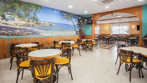 A restaurant with round tables and chairs, a mural of a beach scene, and a checkered floor pattern. - Hotel Playa Sol (Palma de Mallorca)