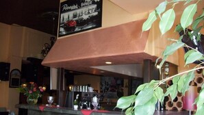 A bar area with a counter, chairs, and a hanging sign above. - Fritzi's Art Hotel (Filderstadt)