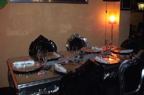 A dining table set with plates, glasses, and a candle. - Fritzi's Art Hotel (Filderstadt)
