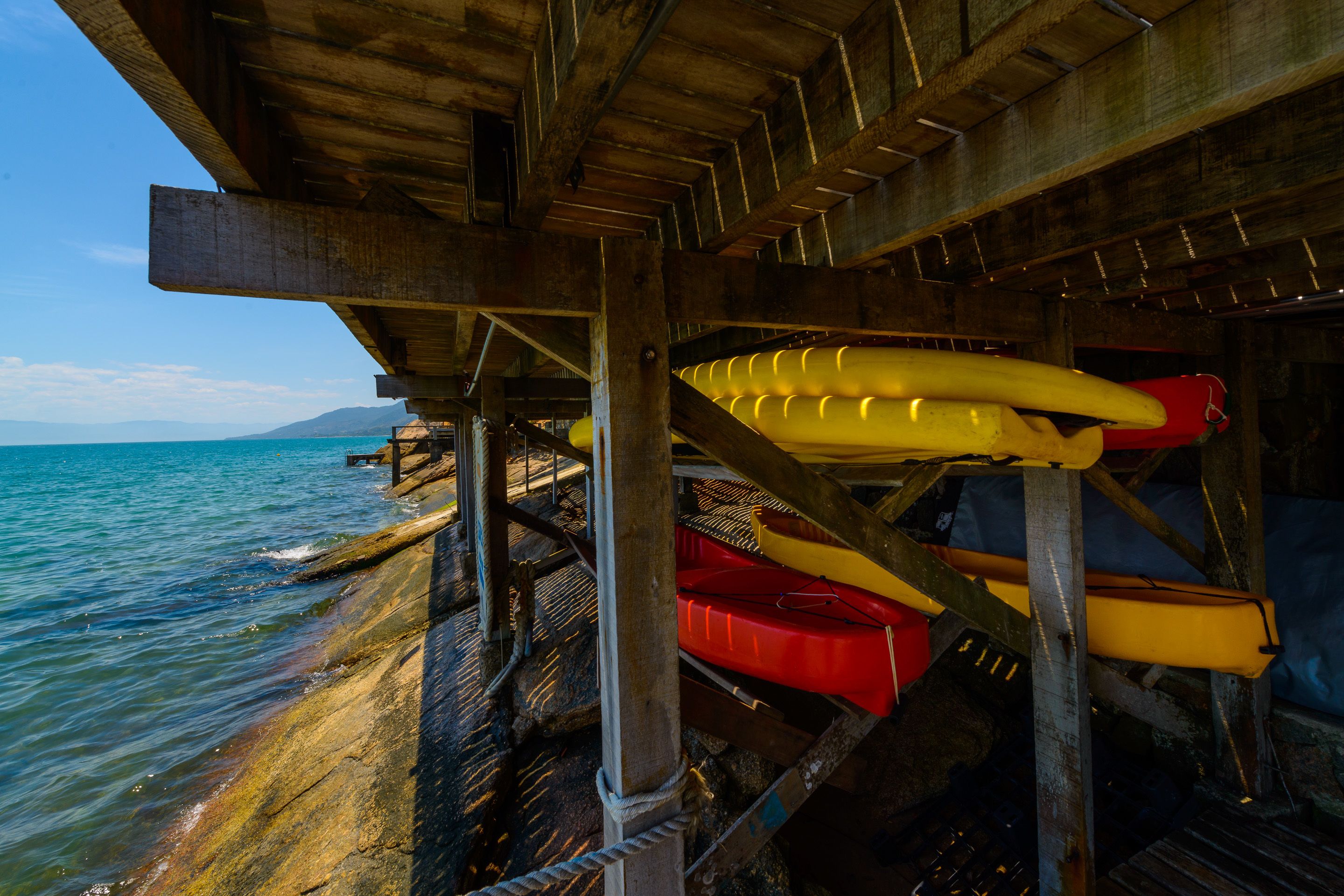 Une jetée avec des kayaks et une côte rocheuse.
