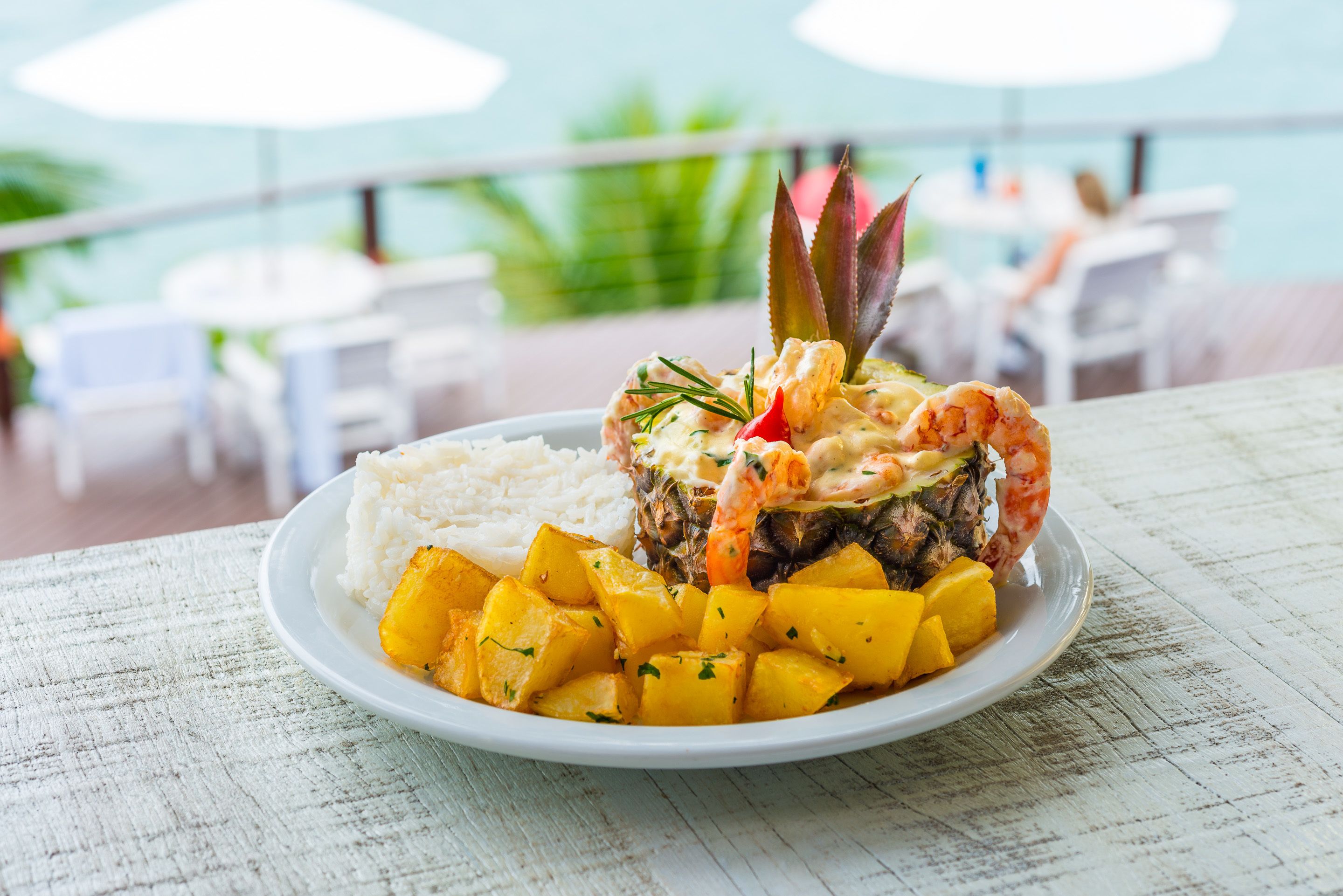 A plate of food with shrimp, pineapple, and rice, served on a white plate.