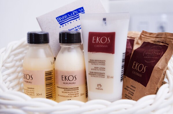 Una cesta con diversos productos de la marca Ekos, incluyendo champú, acondicionador, loción corporal y jabón.