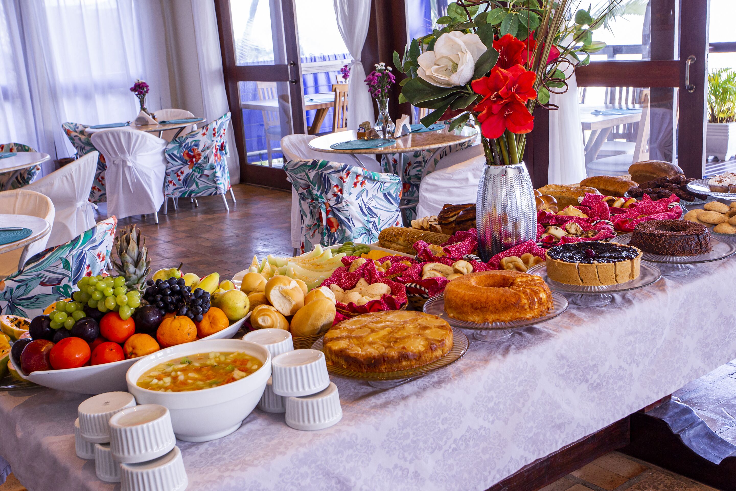A buffet table with a variety of food items and a floral centerpiece.