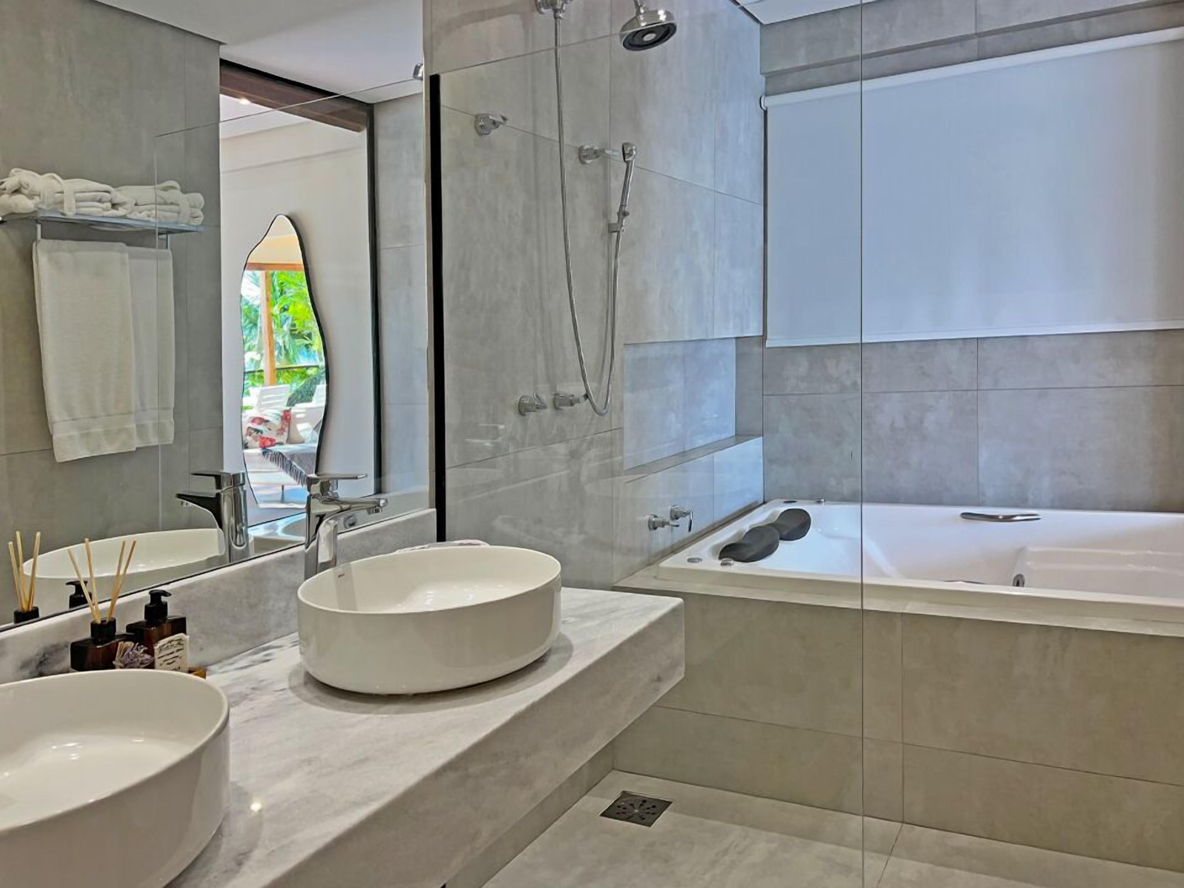 Een moderne badkamer met een groot wastafel, een badkuip en een douche.