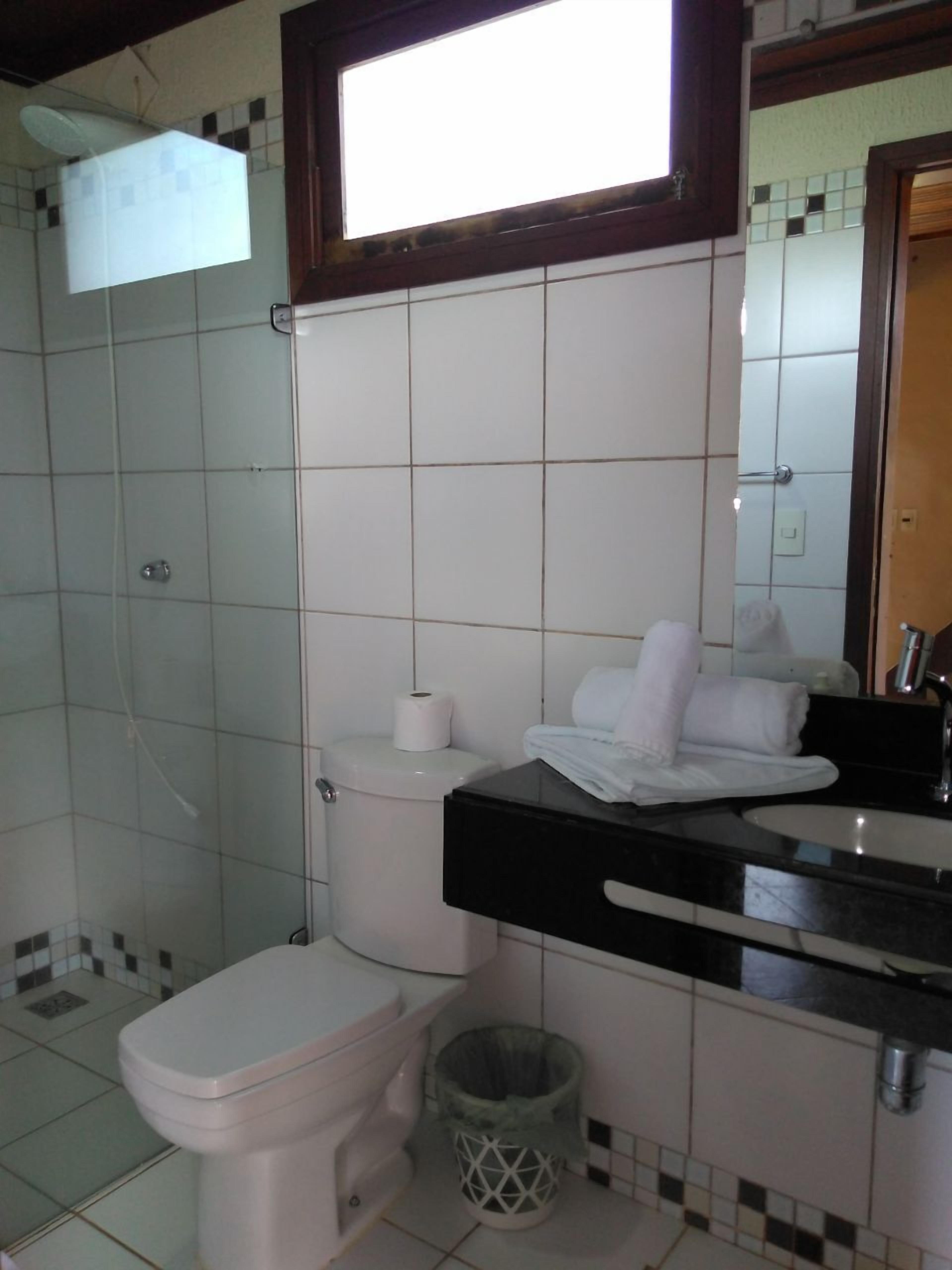 A bathroom with a toilet, sink, and shower.
