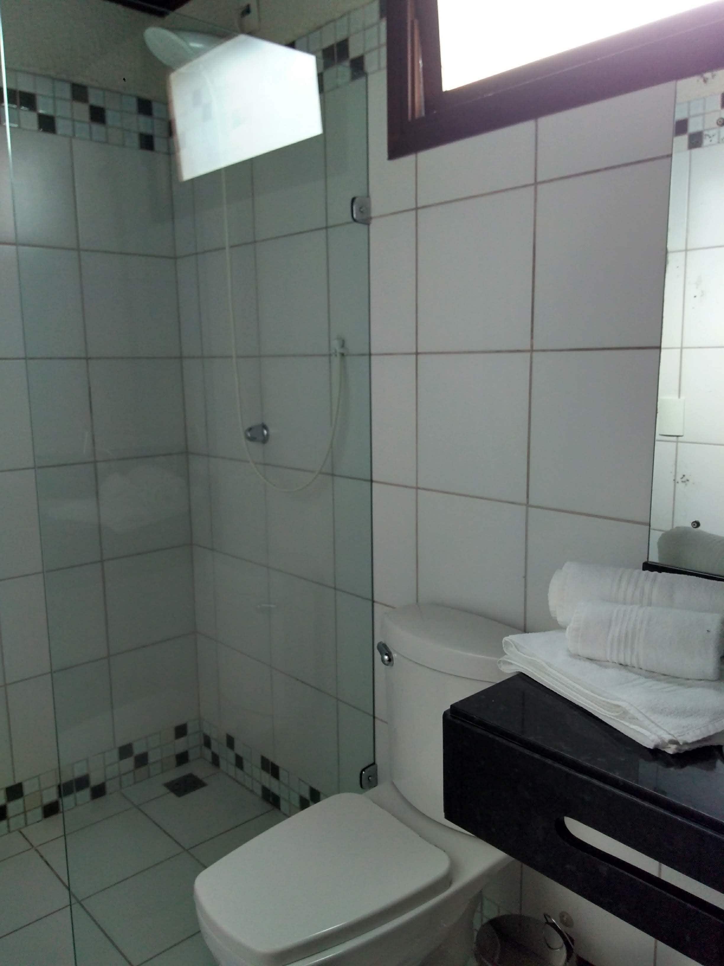 Une salle de bain avec une douche, des toilettes et un lavabo avec un miroir.