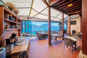 A covered outdoor dining area with a view of the sea and mountains. - Hotel Villa Turka (Alanya)