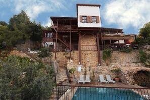A stone building with a pool, wooden deck, and outdoor seating. - Hotel Villa Turka (Alanya)