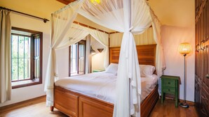 A four-poster canopy bed with a wooden headboard, a bedside table, and a floor lamp. - Hotel Villa Turka (Alanya)