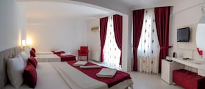 A hotel room with a large bed, two bedside tables, a desk, a chair, and a TV. - Ayapam Hotel (Denizli)