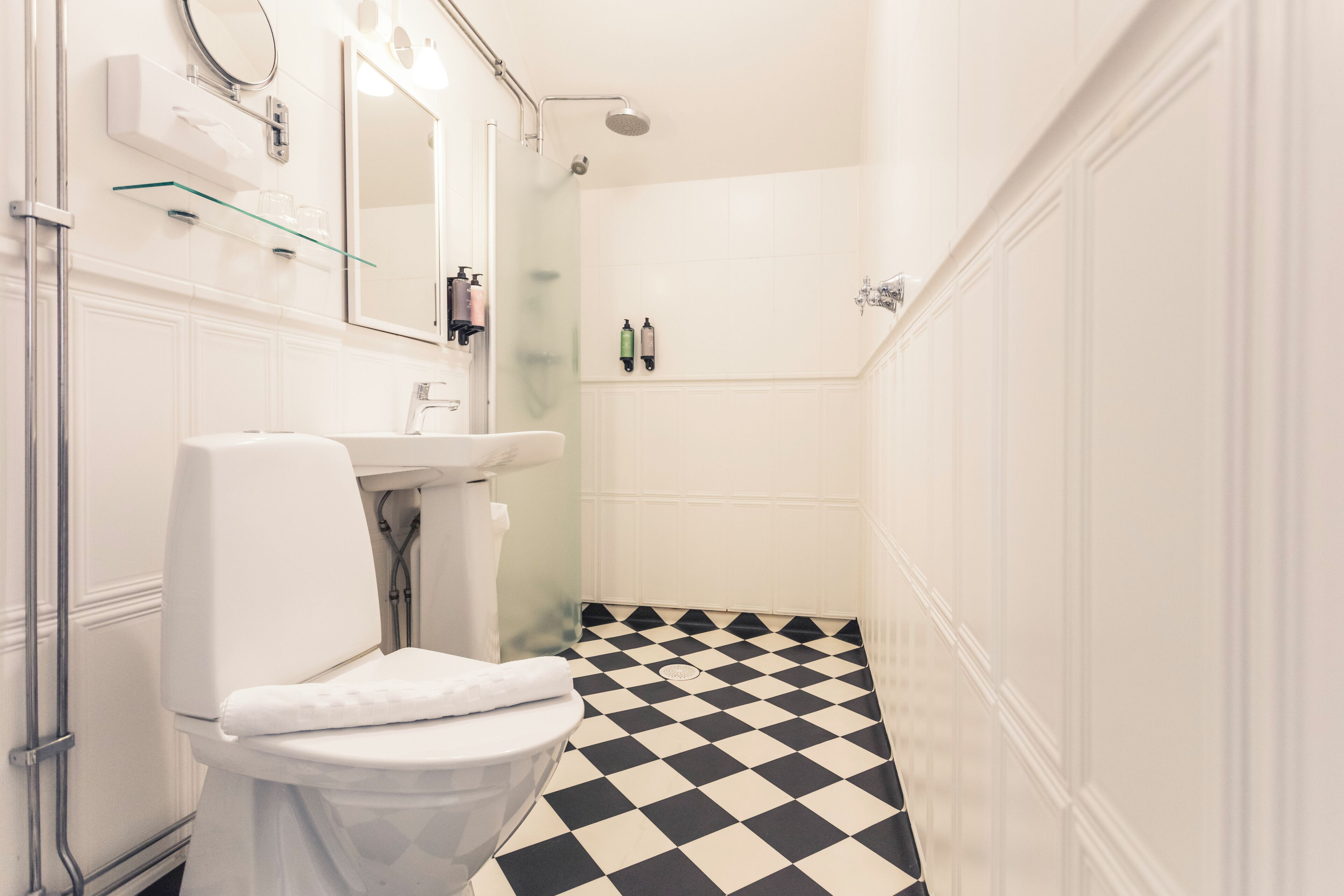 Un baño con inodoro, lavamanos y ducha.