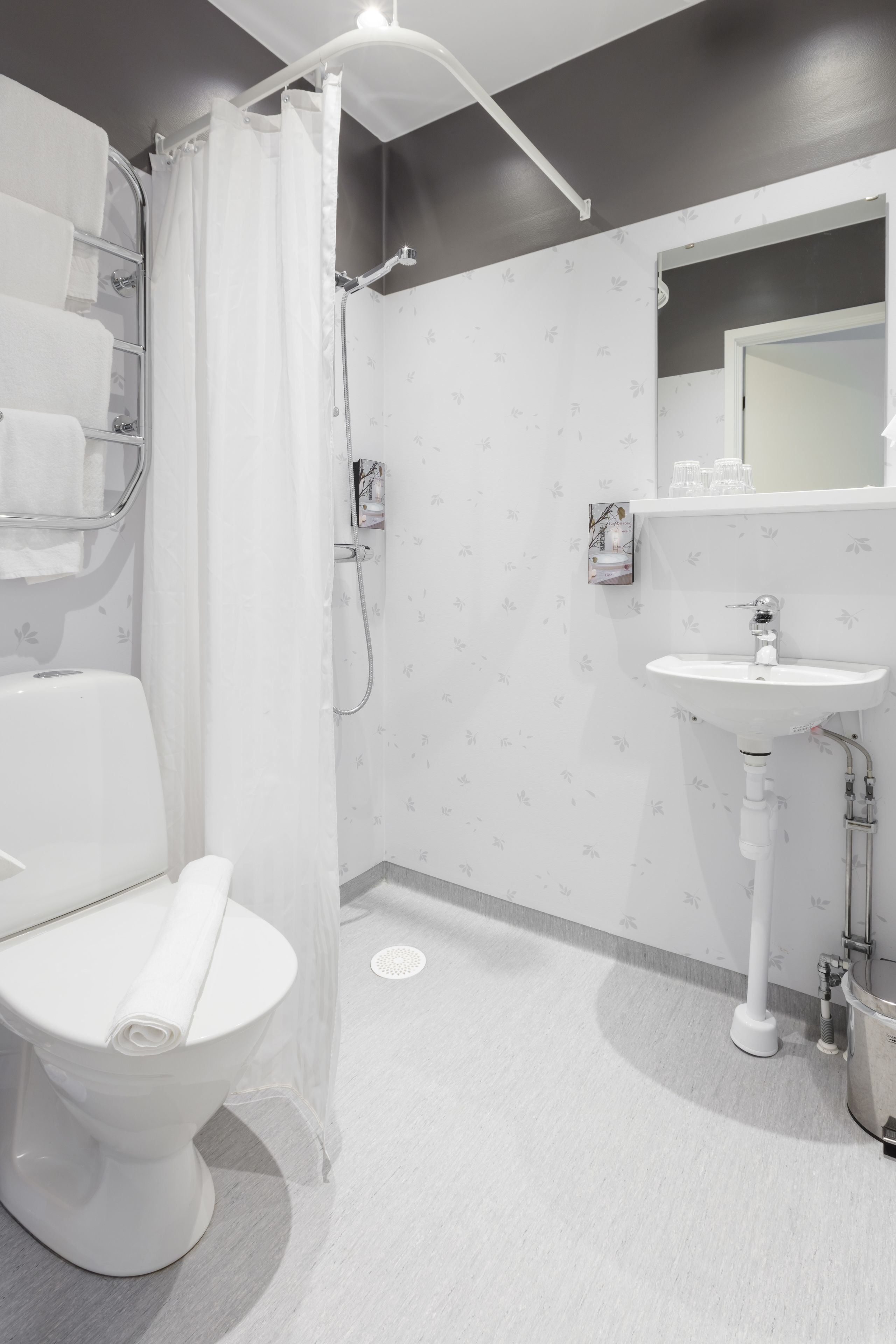A modern bathroom with a toilet, shower, and sink.