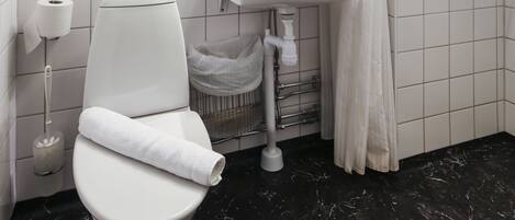 A bathroom with a toilet, sink, and shower.