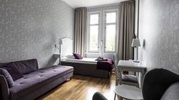 Una camera da letto moderna con un divano, un letto, una scrivania e una sedia.