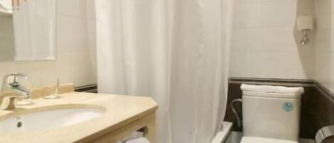 Ein Badezimmer mit Waschbecken, Toilette und Duschvorhang.