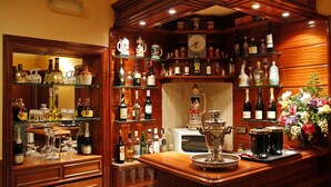 Eine Bar mit Regalen voller Spirituosenflaschen, Gläsern und einer Uhr.