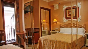 Ein Hotelzimmer mit einem Bett, einem Schreibtisch, einem Stuhl, einem Nachttisch und einem Spiegel.
