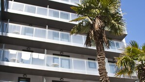 A multi-story hotel with balconies, a palm tree, and a sign that reads "SUMMER HOUSING." - Summer Hotel (Calella)