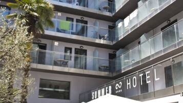 A hotel with outdoor seating and multiple balconies.