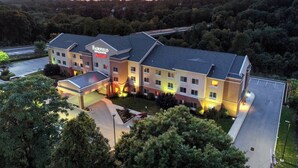 A multi-story hotel with a flat roof, a covered parking area, and a landscaped front yard. - Fairfield Inn & Suites by Marriott Harrisburg West (New Cumberland)