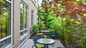 Um pátio com área de estar ao ar livre e vista para um jardim.
