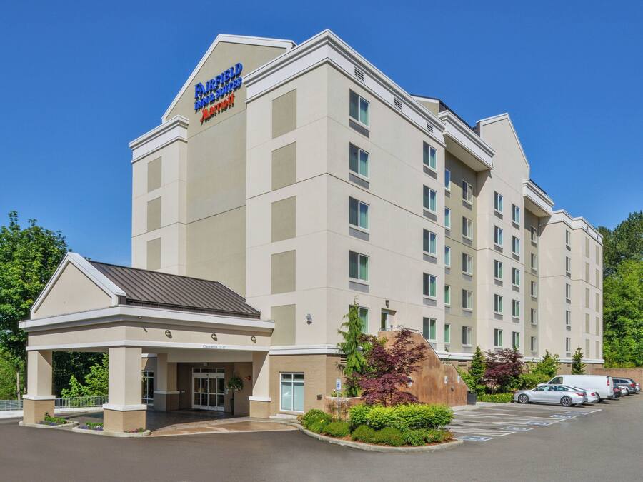 A hotel with a modern design, featuring a covered entrance and multiple floors.