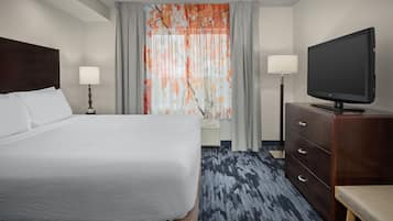 Een hotelkamer met een groot bed, een flatscreen televisie, een dressoir en een bureau.