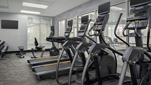 Academia com esteiras, elípticos e bicicleta ergométrica.