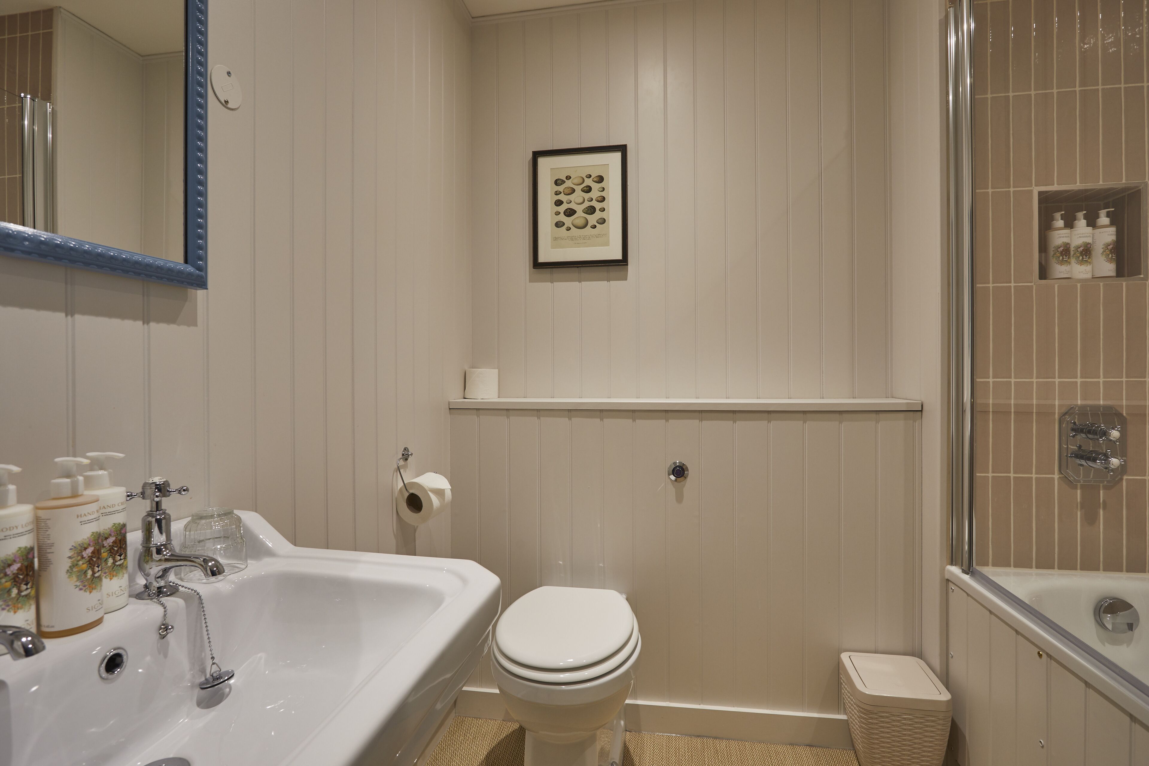 A bathroom with a sink, toilet, and shower area.