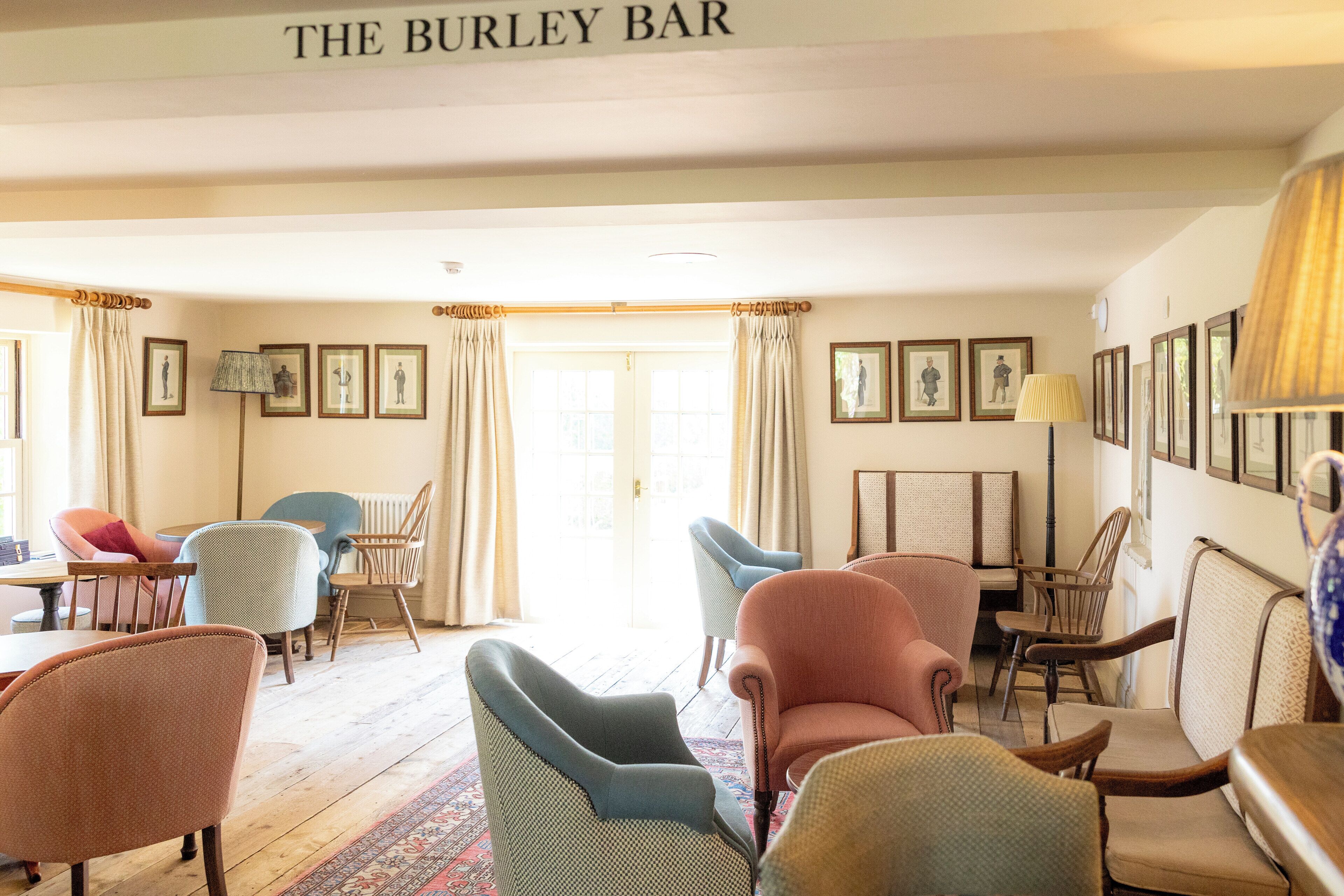 A cozy bar area with various seating options and framed pictures on the walls.