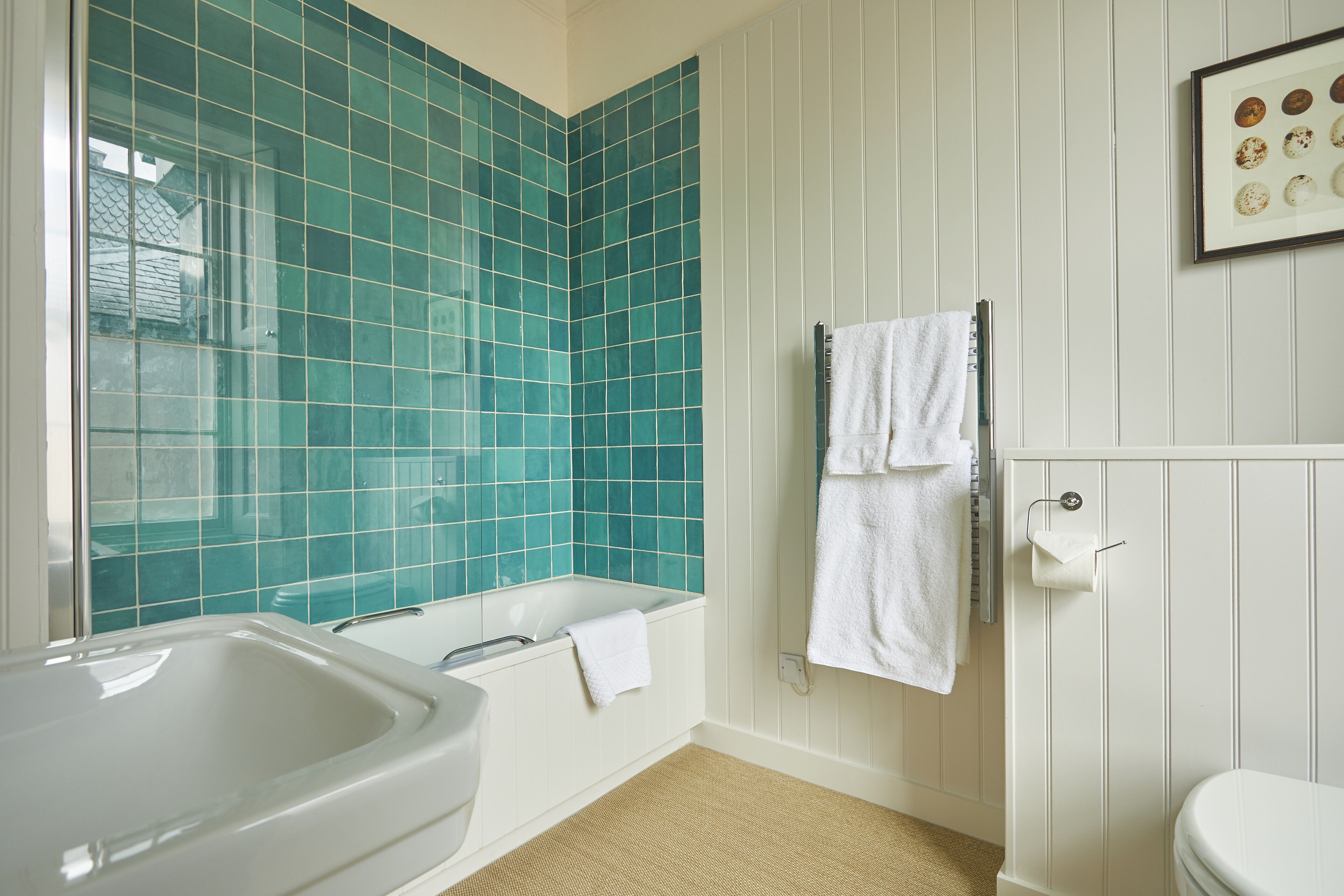Een badkamer met een bad, een toilet en een wastafel.
