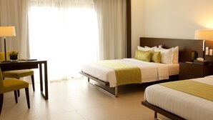 A hotel room with two beds, a desk, and a chair. - Ciriaco Hotel and Resort (Calbayog)