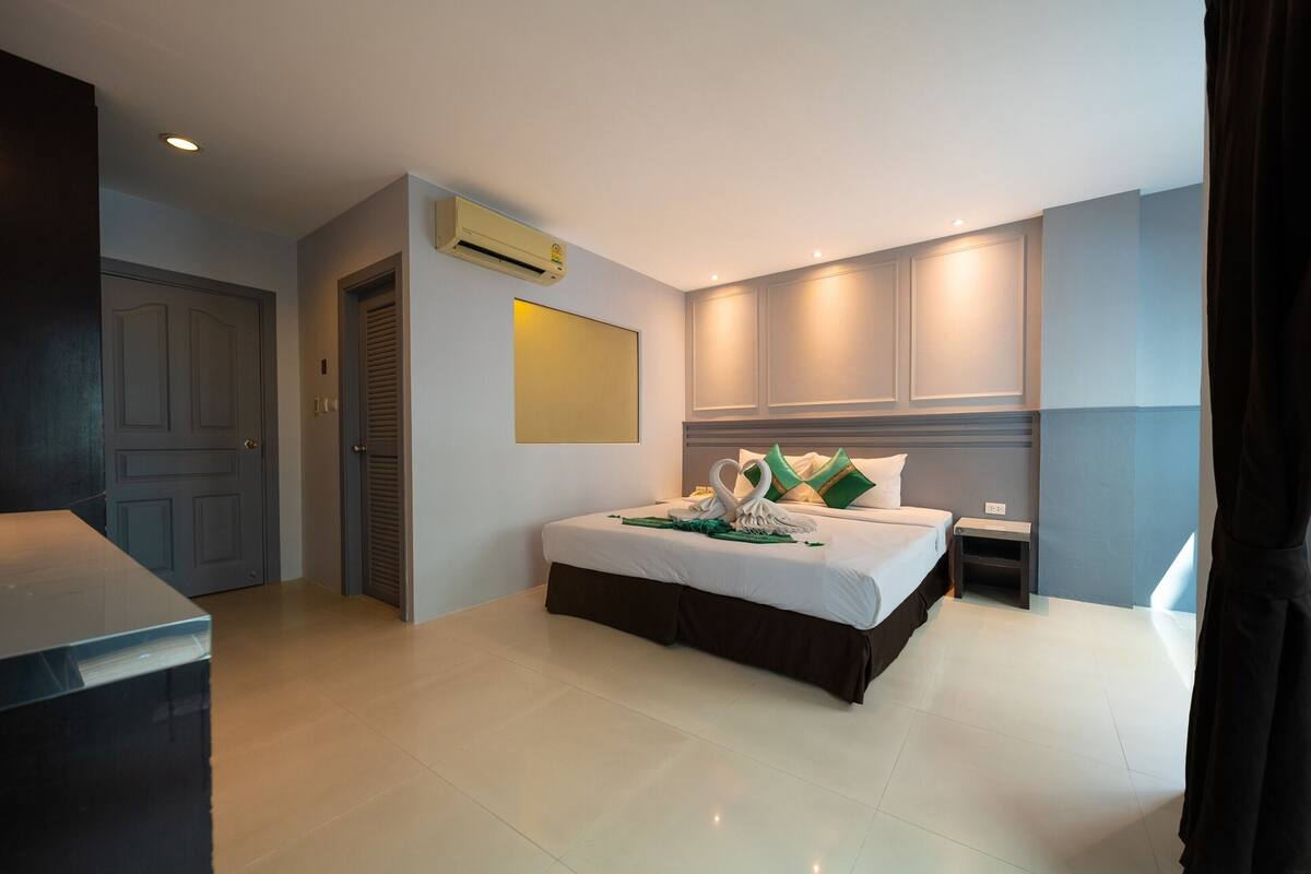 Een moderne hotelkamer met een groot bed, een bureau en een kledingkast.