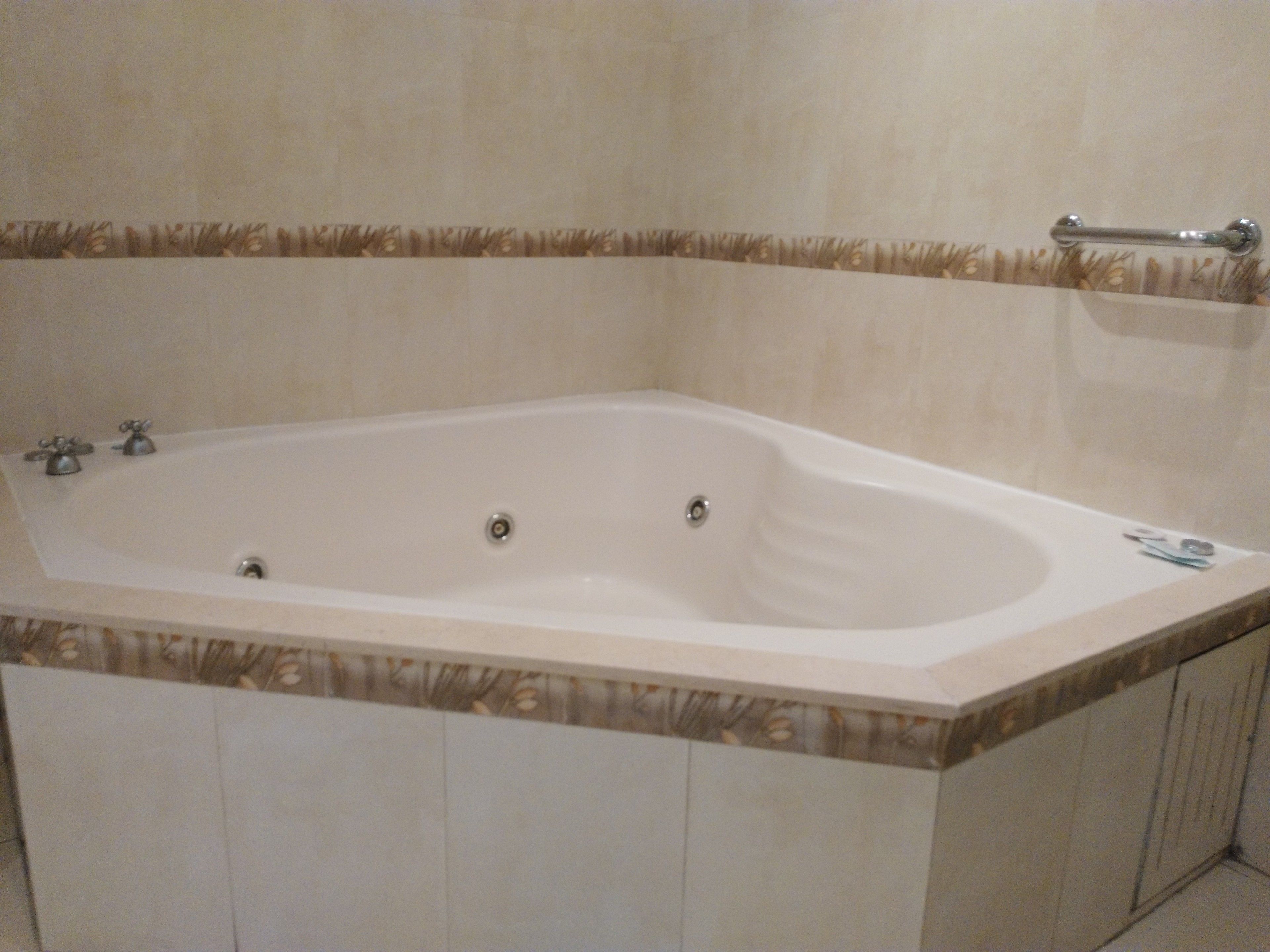 A large, freestanding bathtub with a showerhead and a handheld shower attachment.