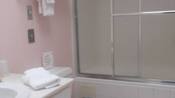 A bathroom with a toilet, sink, and a shower area.