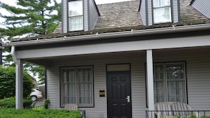 A two-story house with a brick driveway, a black front door, and a mailbox. - Century Suites Hotel (Bloomington)