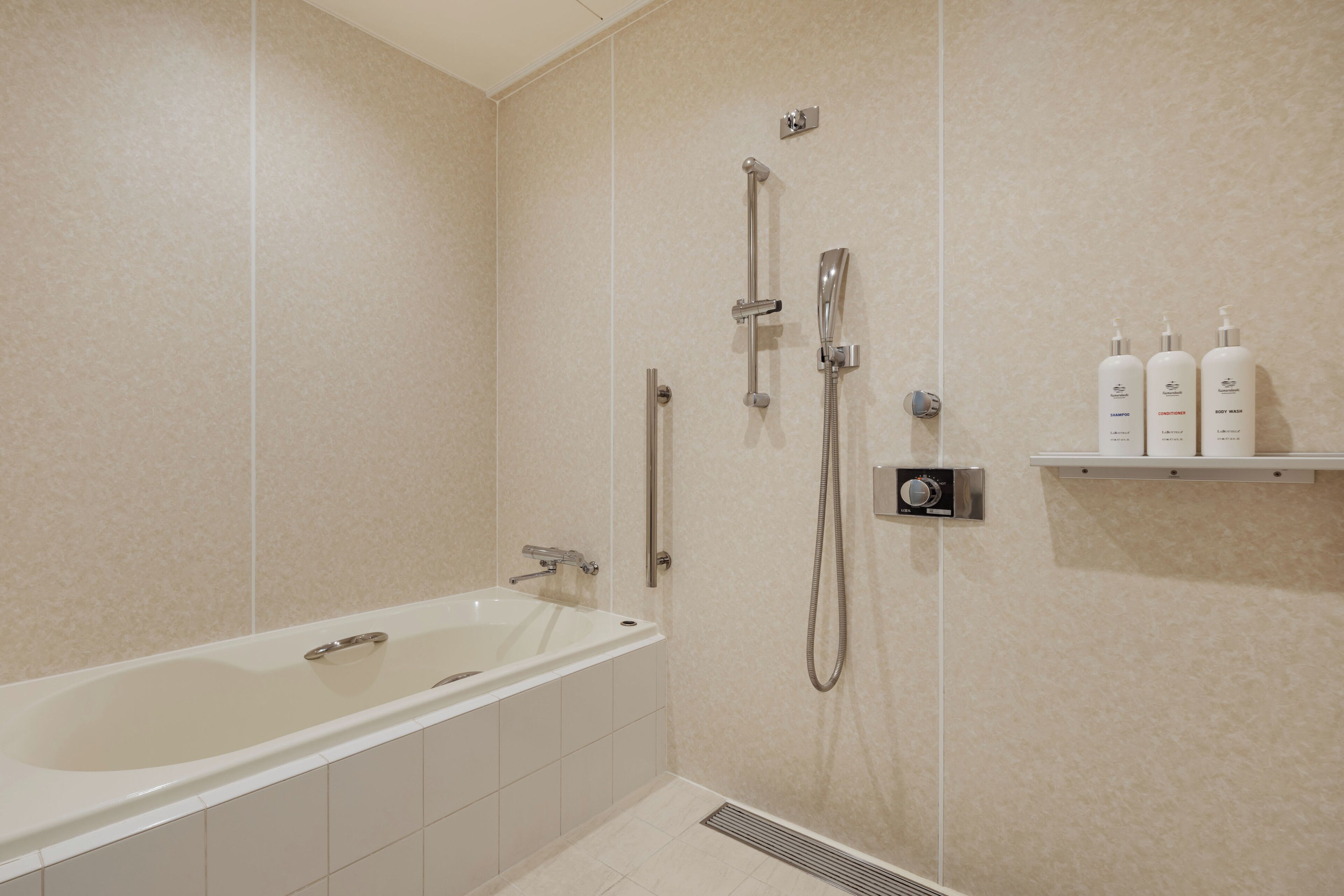 Un bagno moderno con vasca, doccia e uno scaffale con articoli da toilette.