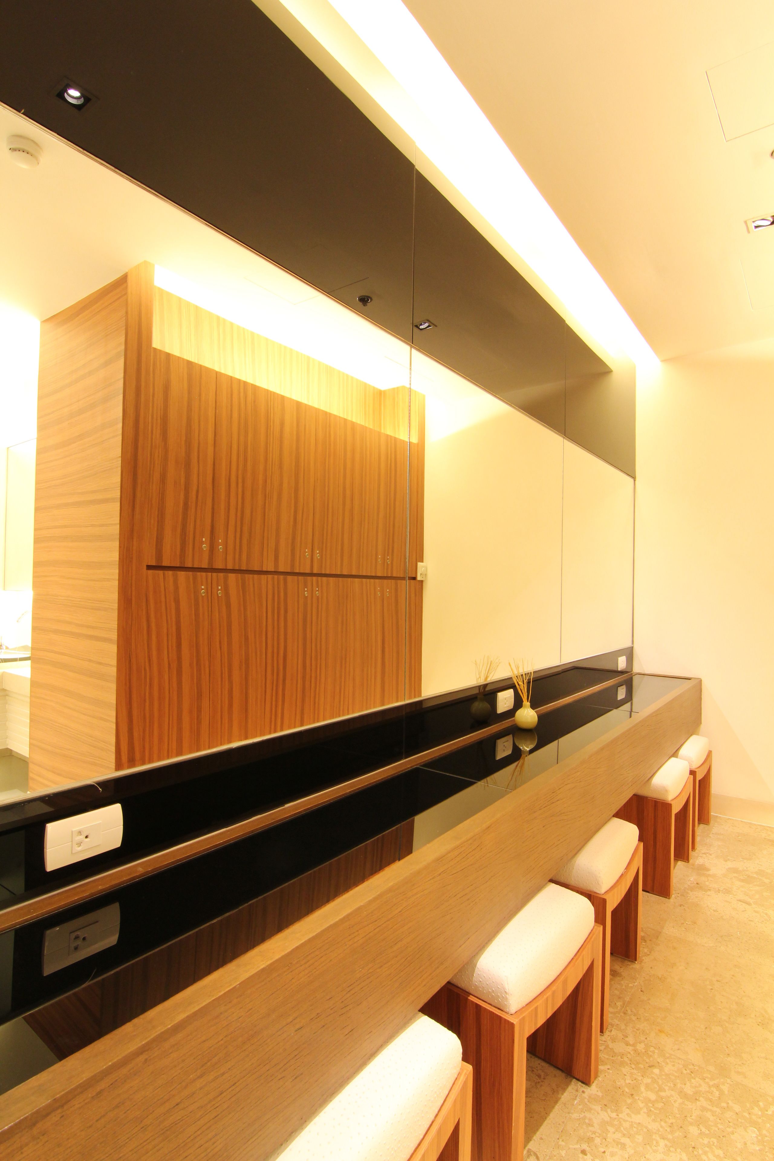 A modern bathroom with a wooden vanity, a black countertop, and a mirror.