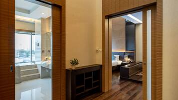 A modern interior with a wooden floor, a fireplace, and a view of the city through large windows.