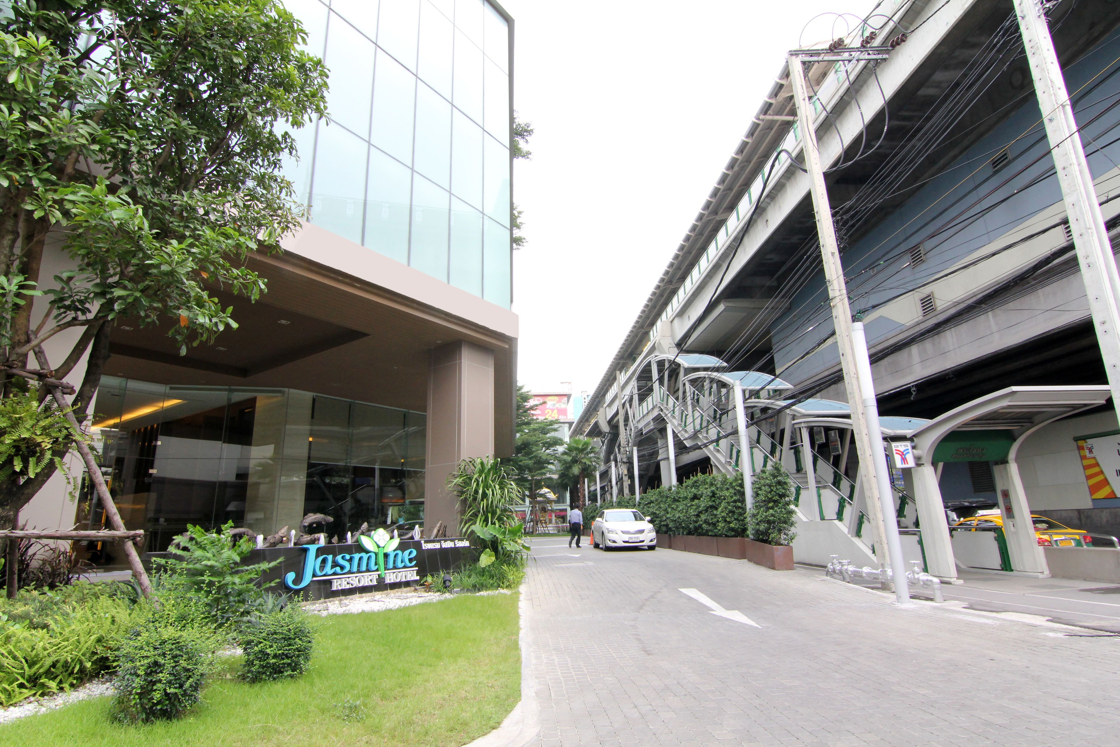 Un edificio moderno con un letrero que indica 'Jasmine Resort'.