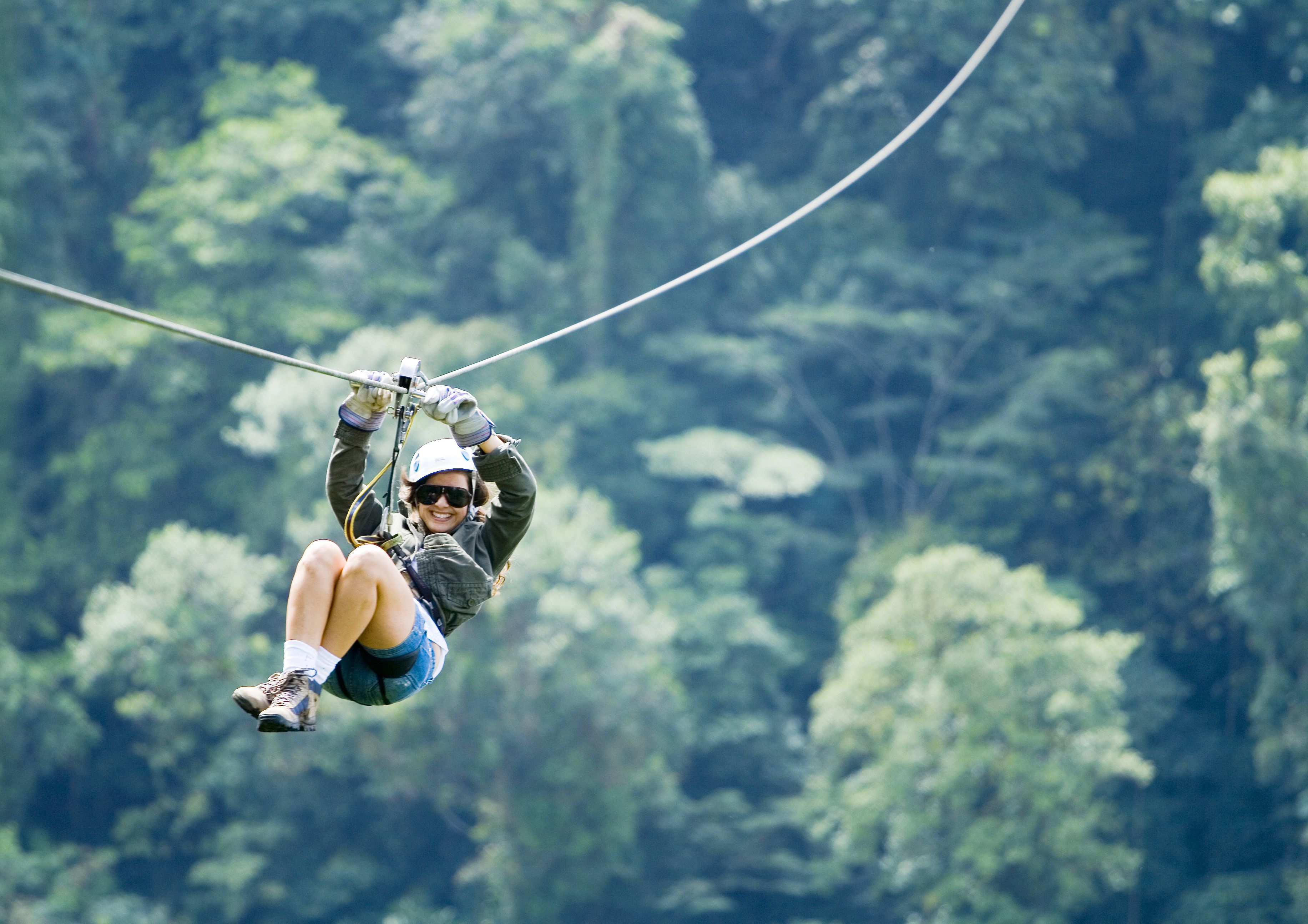 A person ziplining through a forest.