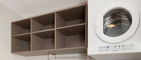 A compact laundry room with a washing machine, a dryer, and a sink.