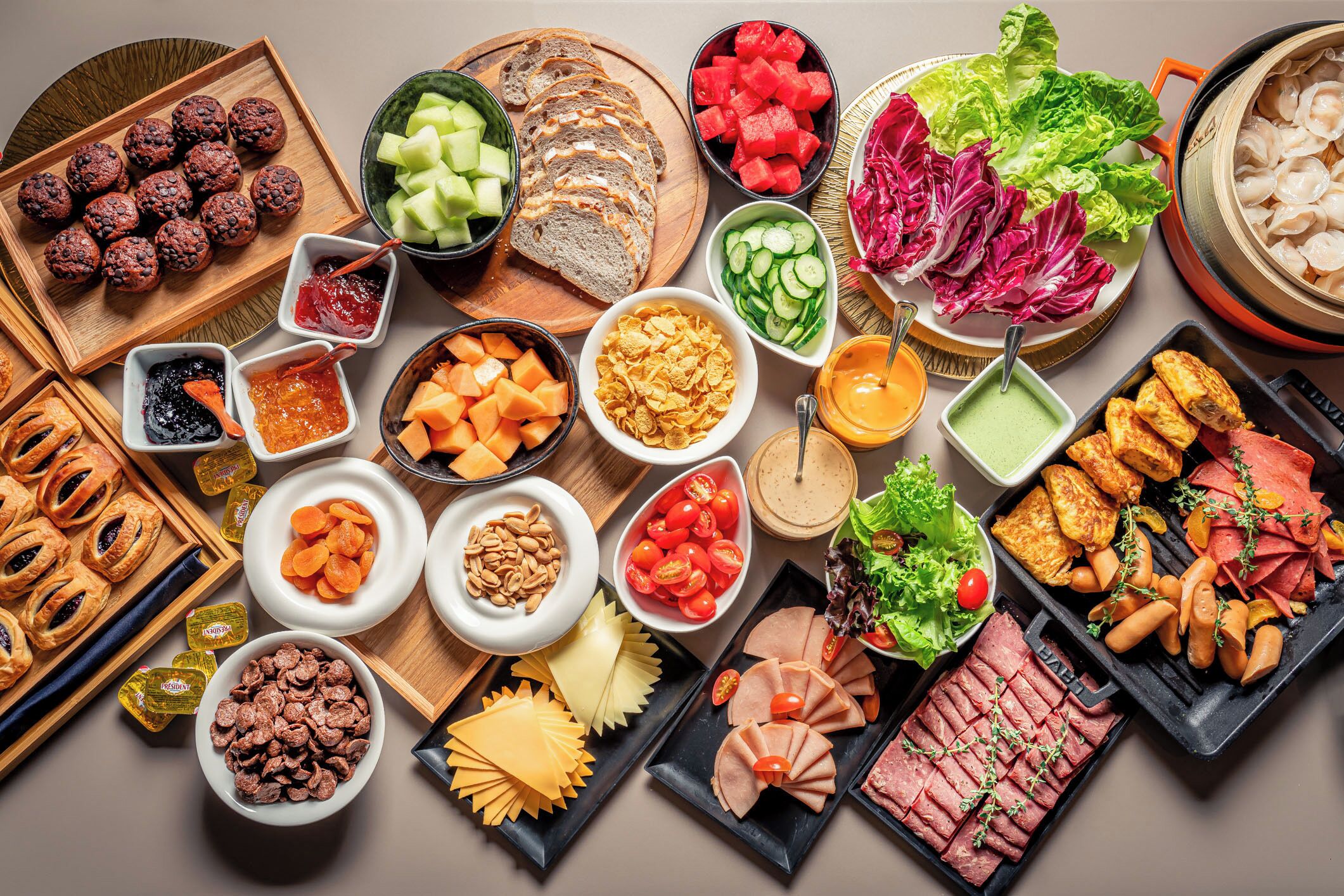 A variety of food items including meats, cheeses, fruits, and vegetables arranged on a table.