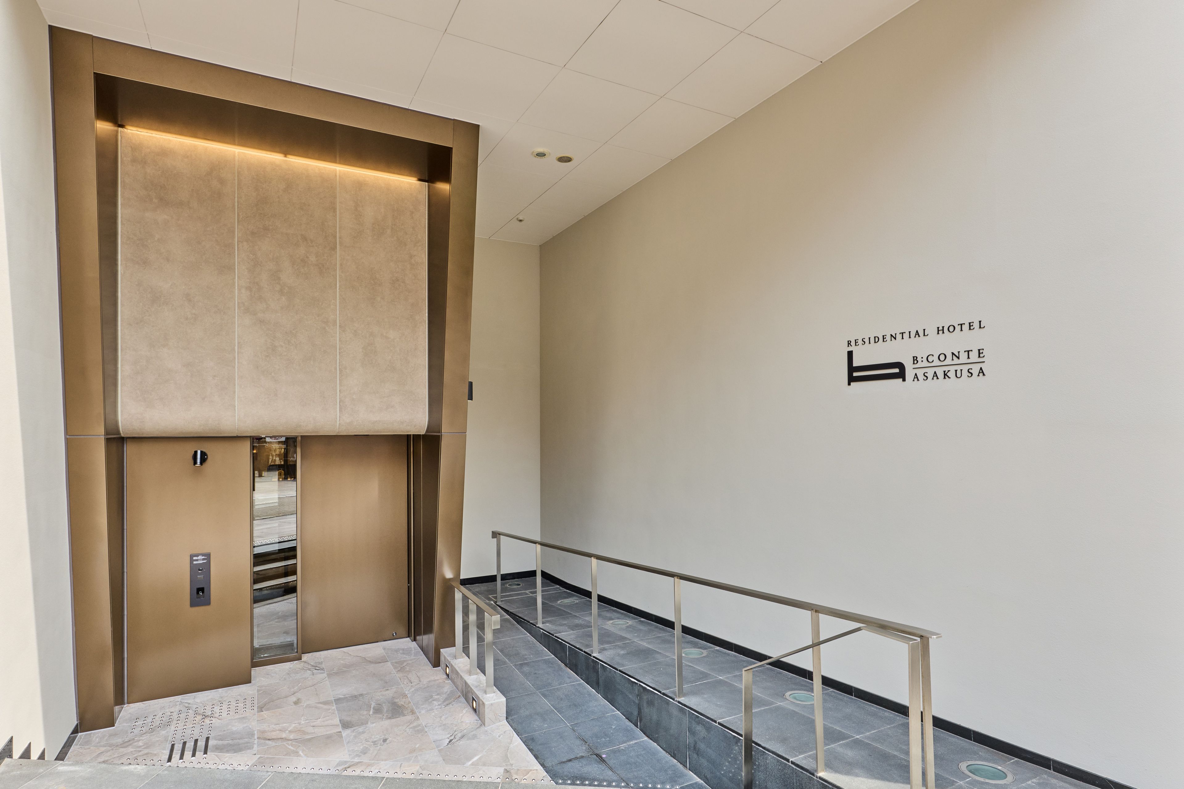 Elevador moderno com acabamento metálico e placa indicando ser um hotel residencial.