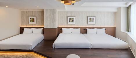 A hotel room with two single beds, a large window, and a modern ceiling light.
